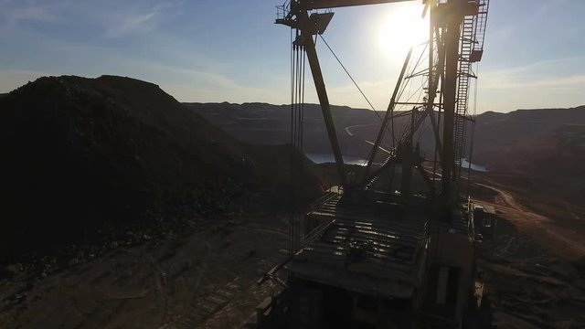Mining boom. Excavator loads ore.Panorama. Artificial lake. Sunset. Development of minerals.