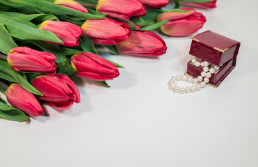 Red spring tulips with small box with pearls romantic present