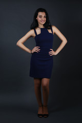 Beautiful female wearing a blue dress over a gray background