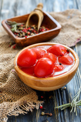Tomatoes in own juice in wooden bowl.