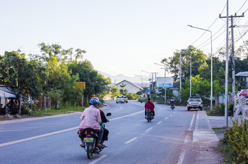 People ride motorcycles on the street in Laos