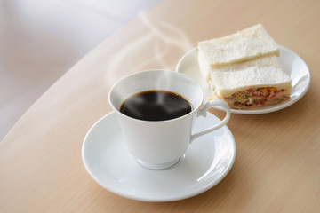 Obraz na płótnie Canvas hot coffee with sandwich on wooden table