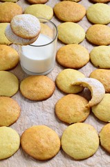 Homemade biscuits on the baking paper and glass of milk