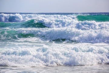 Breaking wave. Empty green wave rolls through to beach with no surfer in view