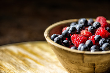 Holzschale mit Blaubeeren und Hinbeeren