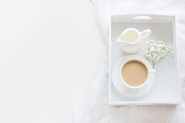 Morning romance breakfast, cup of coffee, milk jug and cake. Spring concept. Top view and copy space.