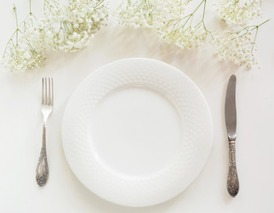 Elegance table setting with gypsophila on white background. Top view.