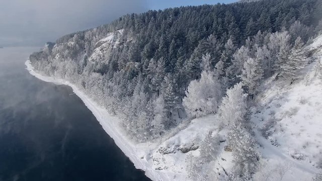 Beautiful winter landscape. Trees covered with snow on the banks of the river. Siberia. The Yenisei.