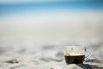 Coffee cup on sand & sea background