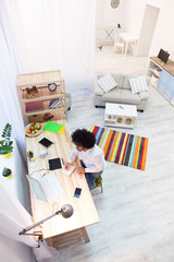 Top view of hipster freelance man's working area at home. Handsome man sitting at table and working in front of laptop computer.