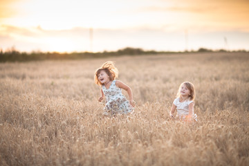 Fototapeta premium Two emotional sisters girls dance at sunset