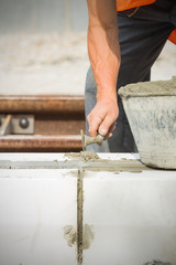 Construction worker wotking hard and leveling concrete pavement outdoors.