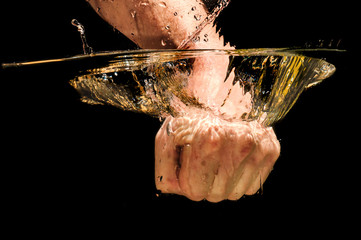 Men fist immersed in water with great speed, studio shot