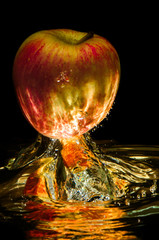 Apples in water with reflection and splash on black background