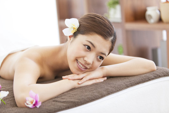 Young woman relaxing on massage table at spa