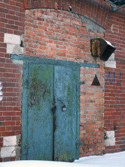 The old rusty door and the brick wall (the old abandoned factory in Russia) 