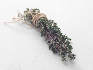 Bunch of fresh garden thyme arranged on white wooden table. Selective focus. Copy space for your text.