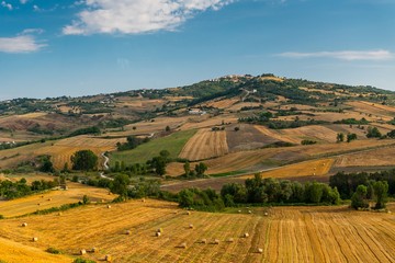 Fototapeta na wymiar Summer landscape with hillside and blue sky in Italy