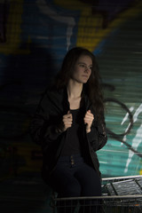 Obraz premium tough girl in front of Graffiti Wall 