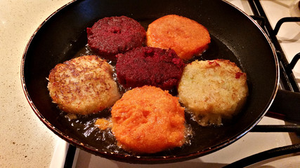 Juicy appetizing multicolored cutlets from carrots, beets and cabbage fried on a pan