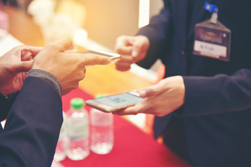education people hold cellphone in hands at information desk is sharing data for register the conference via smartphone. Modern communication technology, business presentation.