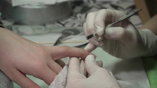 Manicure master cutting the cuticula