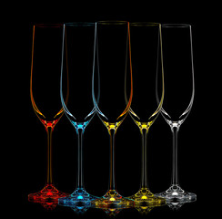 Silhouette of multicolor champagne glass on black background.