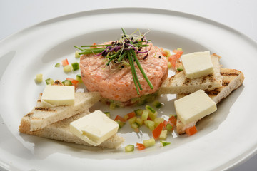 Fresh tartar with salmon, cucumber  on white plate,