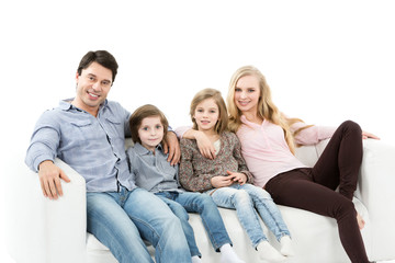 A happy family with kids on the couch isolated.