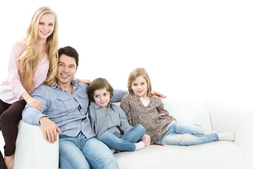 Young parents with children on the couch isolated.