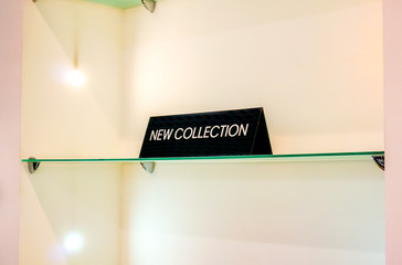 black plate in a clothing store with a sign NEW COLLECTION