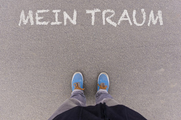 Mein Traum, German text for My Dream text on asphalt ground, feet and shoes on floor