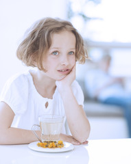 Young girl with cup of tea and flowers