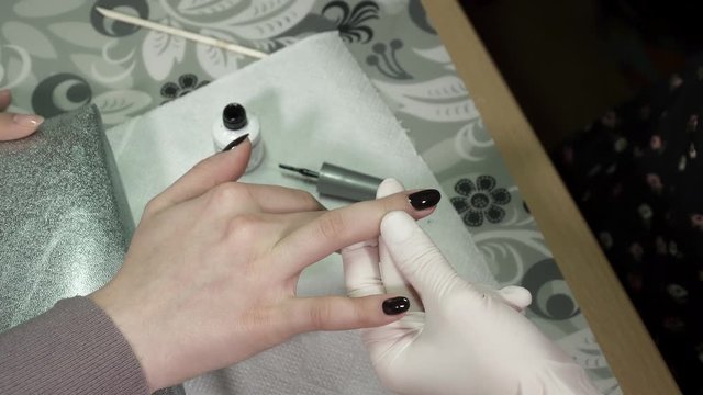 Manicure master polishing nails with the gel polish