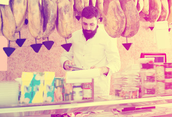 Happy man seller in butcher’s shop