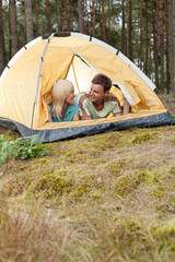 Romantic young couple camping in forest