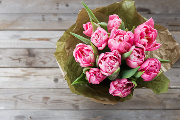 Bouquet of pink peony tulips on a wooden background. Spring flowers. Mother's Day background.