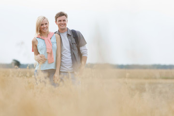 Obraz premium Happy young couple standing at field