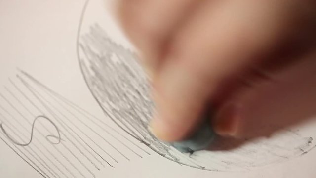 The eraser wipes the drawing with a simple pencil. Hand close up