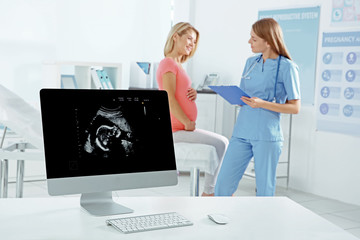 Fototapeta premium Gynecology consultation. Ultrasound picture of child on screen