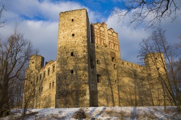 Fototapeta na wymiar Well-preserved ruin of Gothic and Renaissance styles castle of the Archbishop of Gniezno by the Drzewiczka River in Drzewica in warm light of sunset, Poland