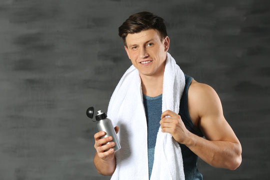 Young handsome sportsman on color background