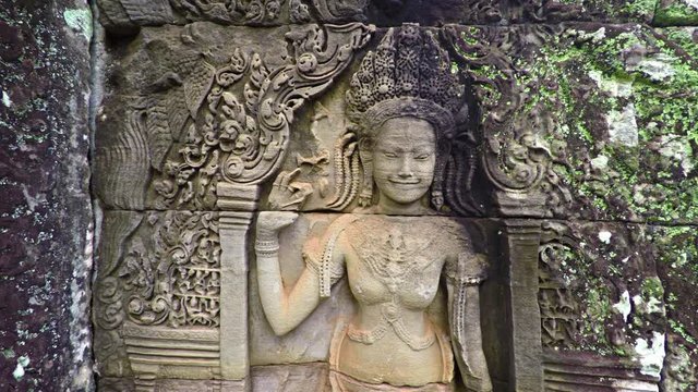Woman carved on stone wall of an ancient temple. Cambodia, Bayon