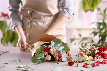 Female florist making beautiful bouquet - obrazy, fototapety, plakaty