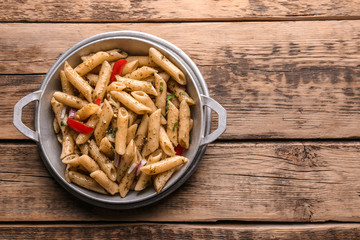 Plate with delicious pasta on wooden background