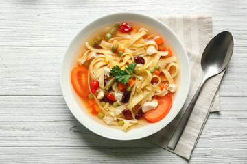 Chicken tortilla soup in plate on wooden table