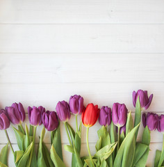 many purple tulips on wooden table