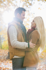 Fototapeta premium Side view of couple hugging in park