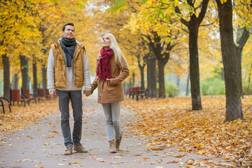 Full length of couple walking while looking up in park during autumn
