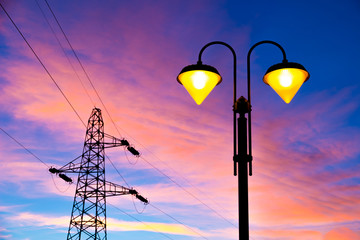 electricity pylon and streetlamp at sunset